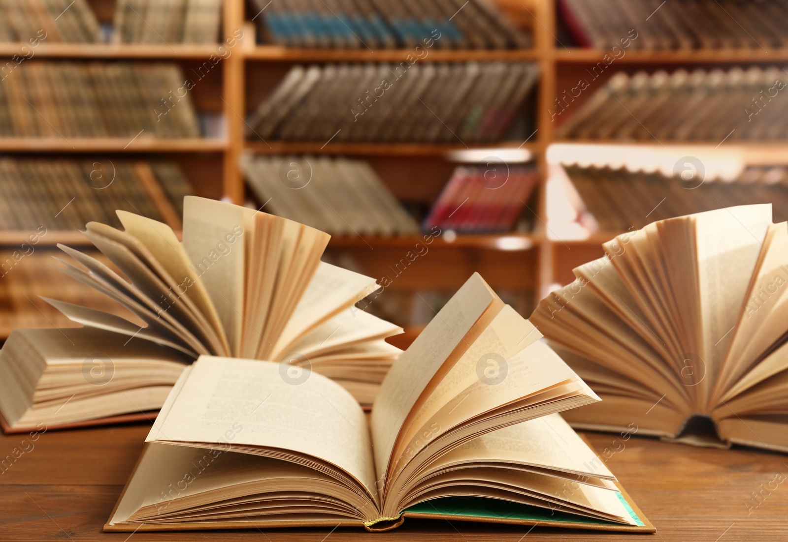 Image of Open books on wooden table in library