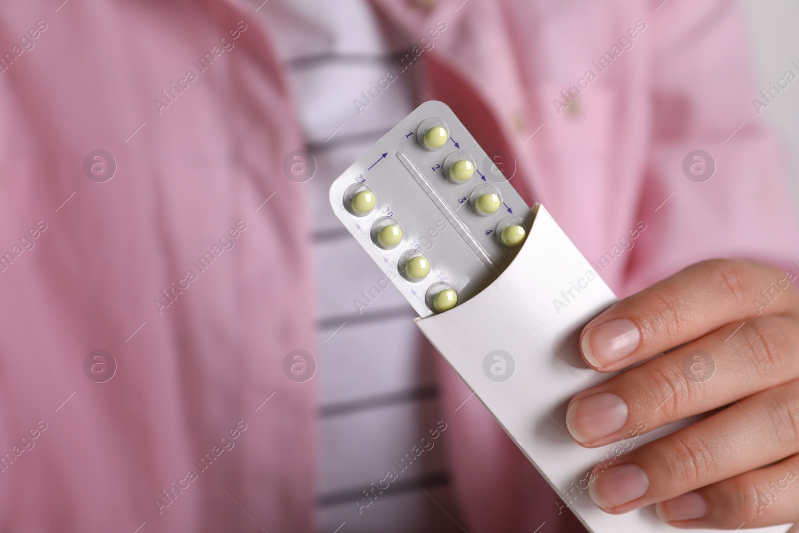 Photo of Woman holding blister of oral contraceptive pills, closeup