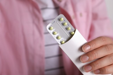 Woman holding blister of oral contraceptive pills, closeup