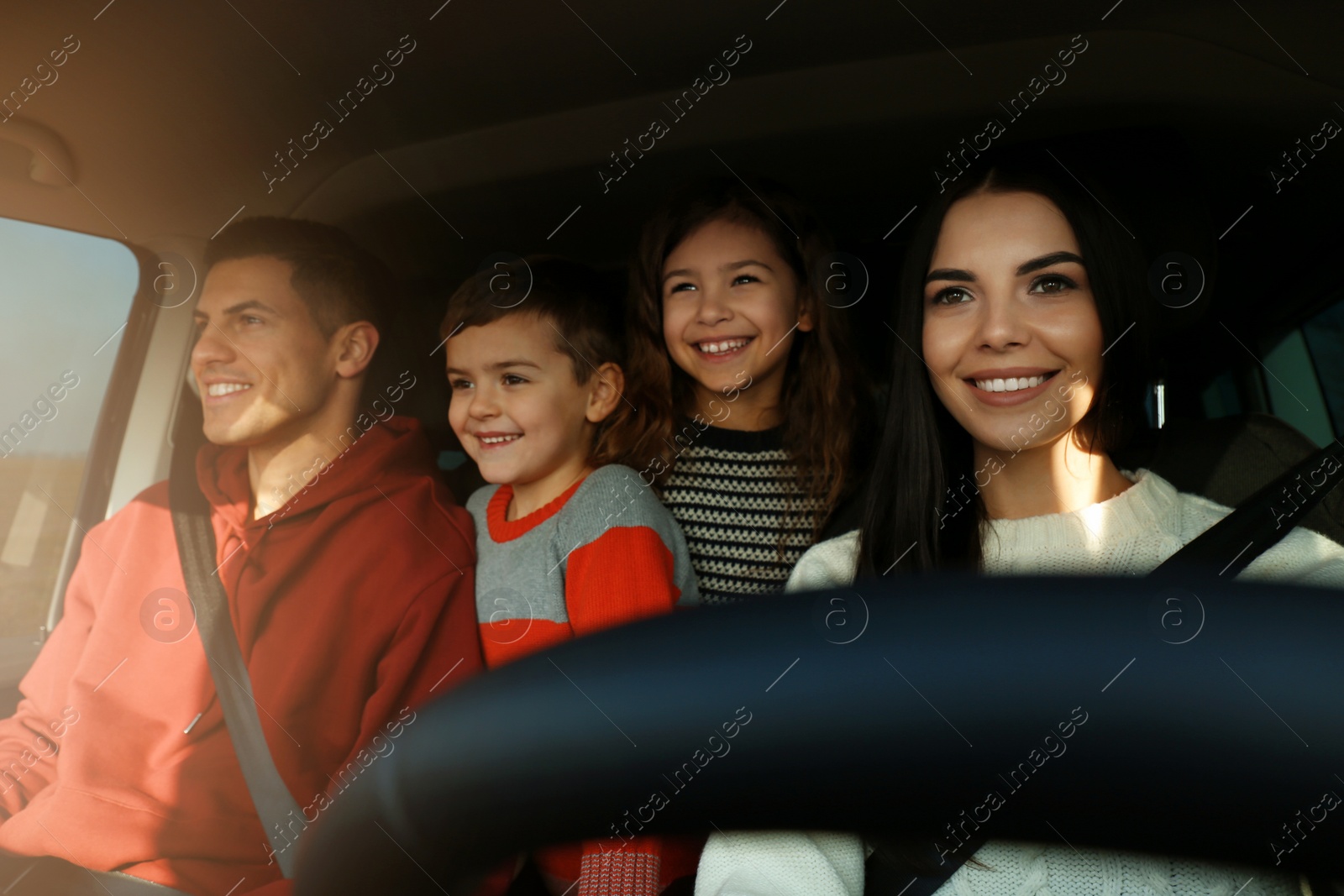 Photo of Happy family with little children inside modern car