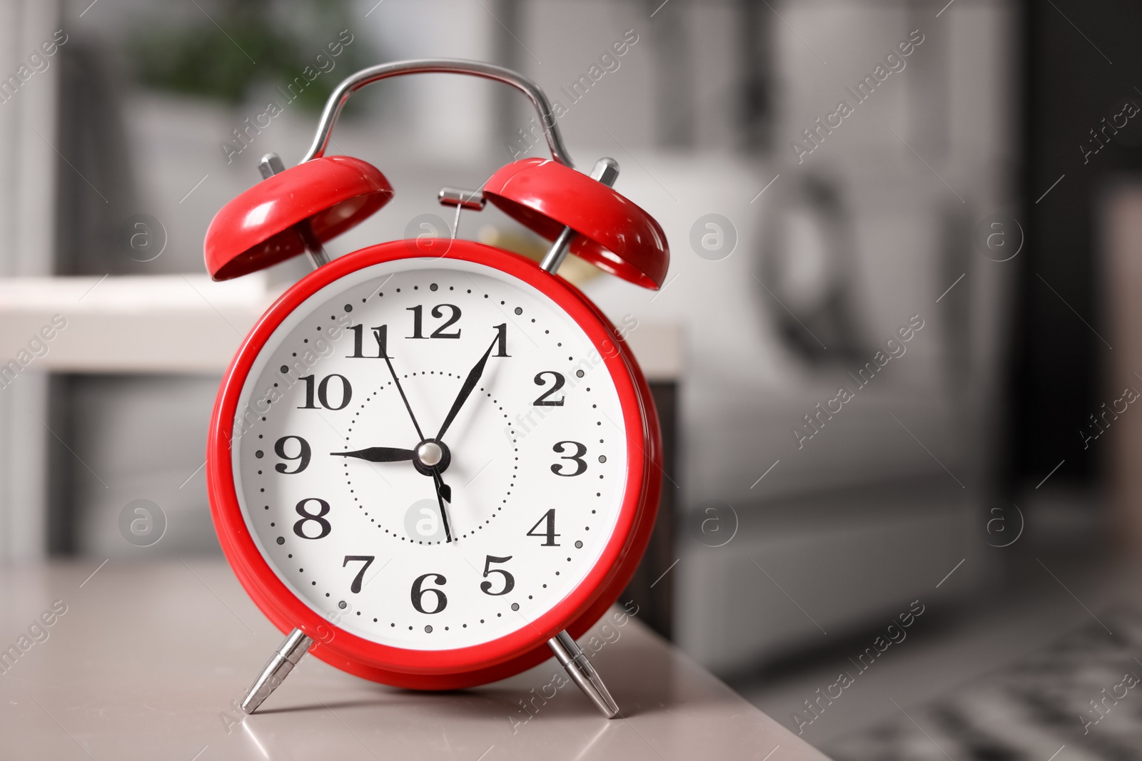 Photo of Alarm clock on table in living room. Time of day