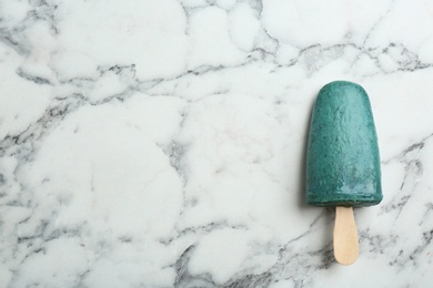 Photo of Delicious spirulina popsicle on marble table, top view. Space for text