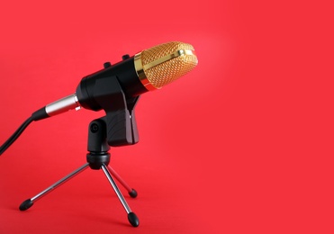 Condenser microphone on color background, space for text