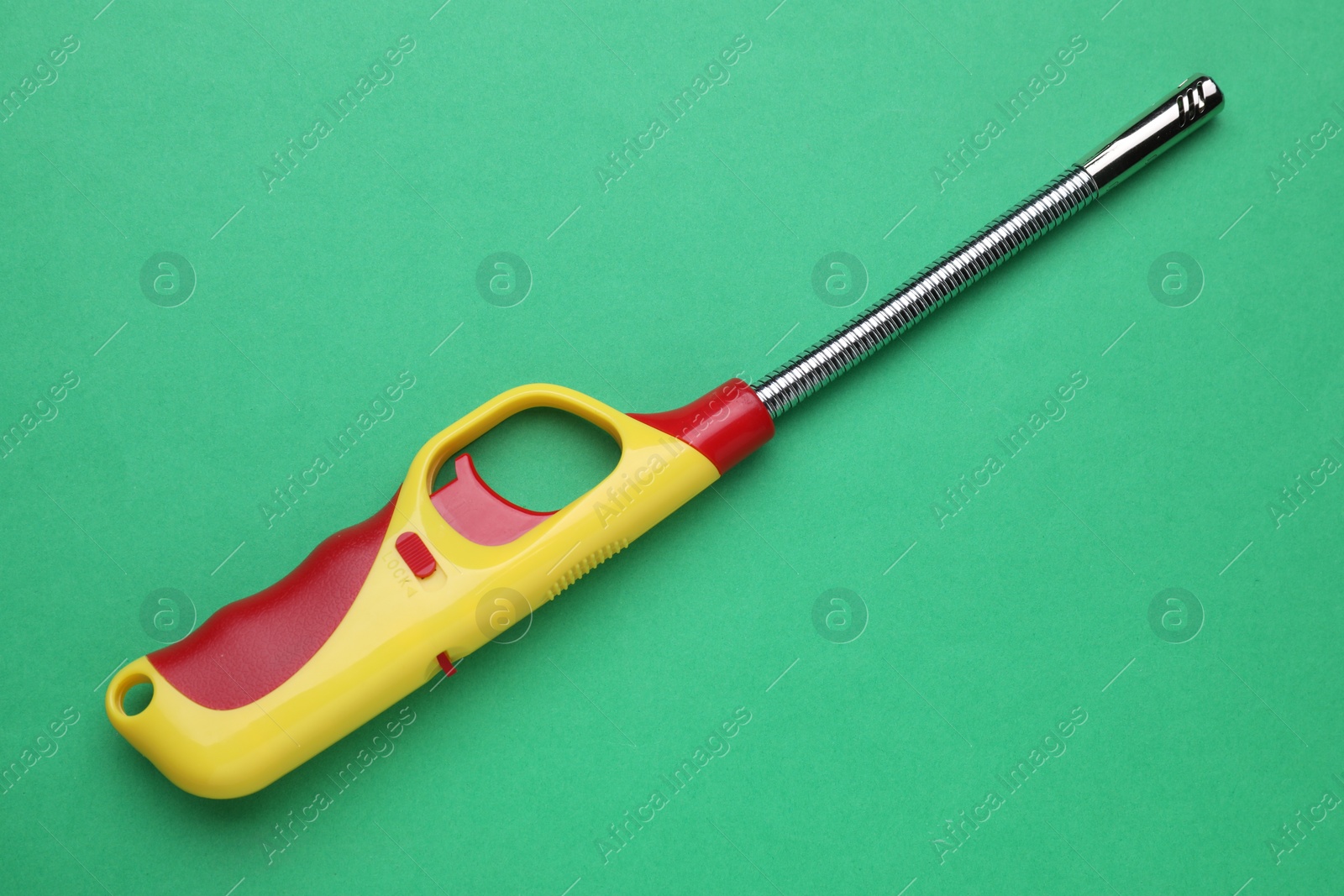 Photo of One gas lighter on green background, top view