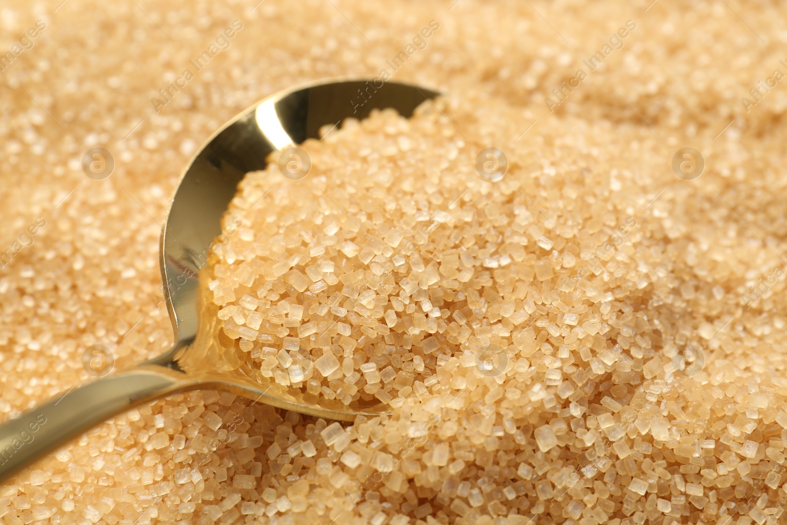 Photo of Spoon on granulated brown sugar, closeup view