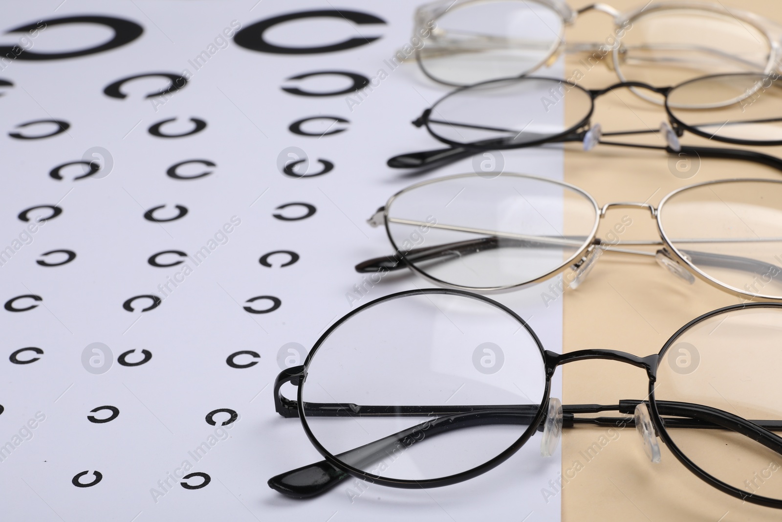 Photo of Vision test chart and glasses on table, closeup