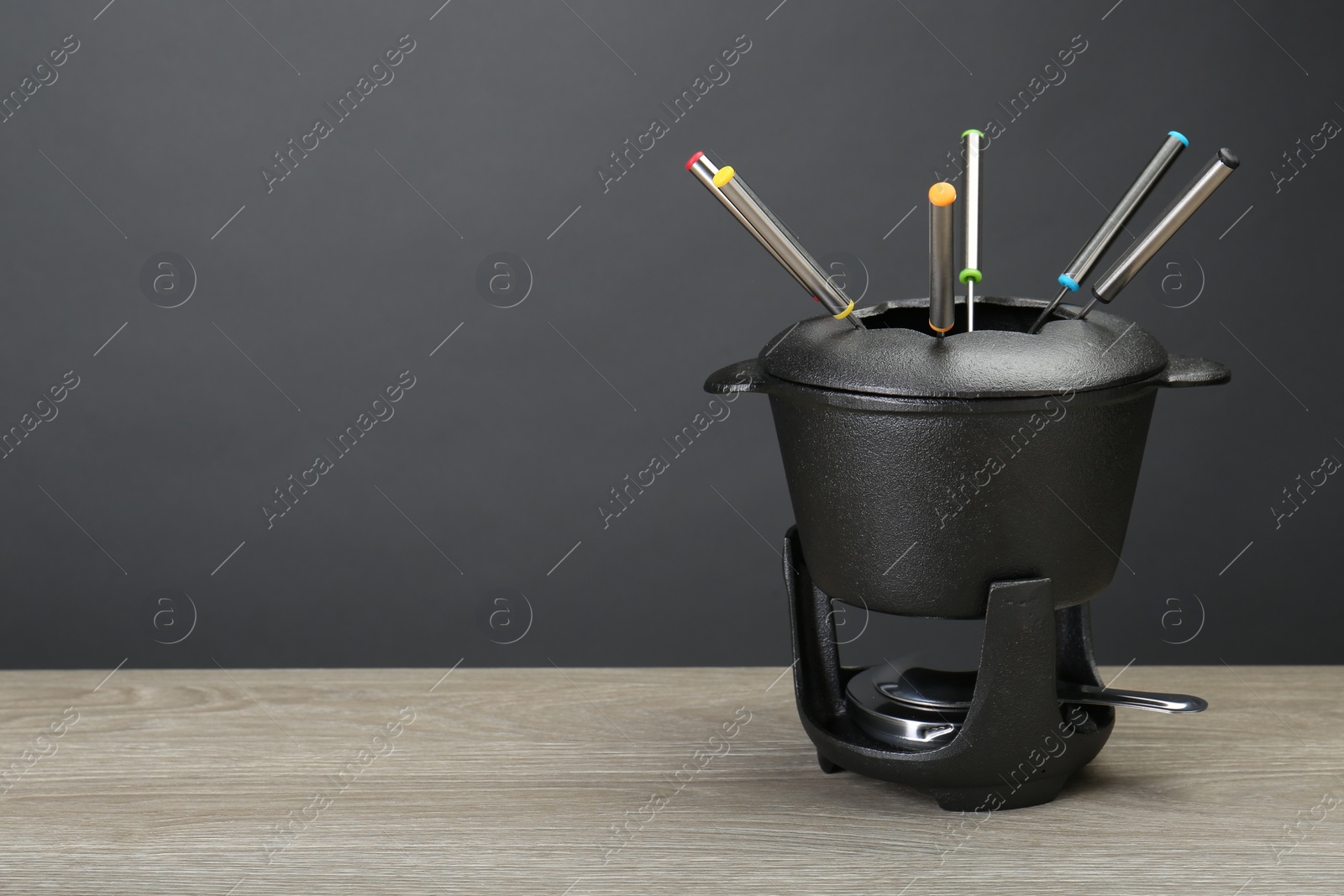 Photo of Fondue set on wooden table, space for text