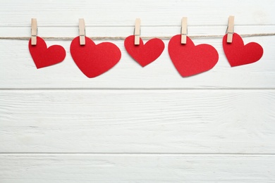 Twine with red decorative hearts and space for text on white wooden table, flat lay. Valentine's Day