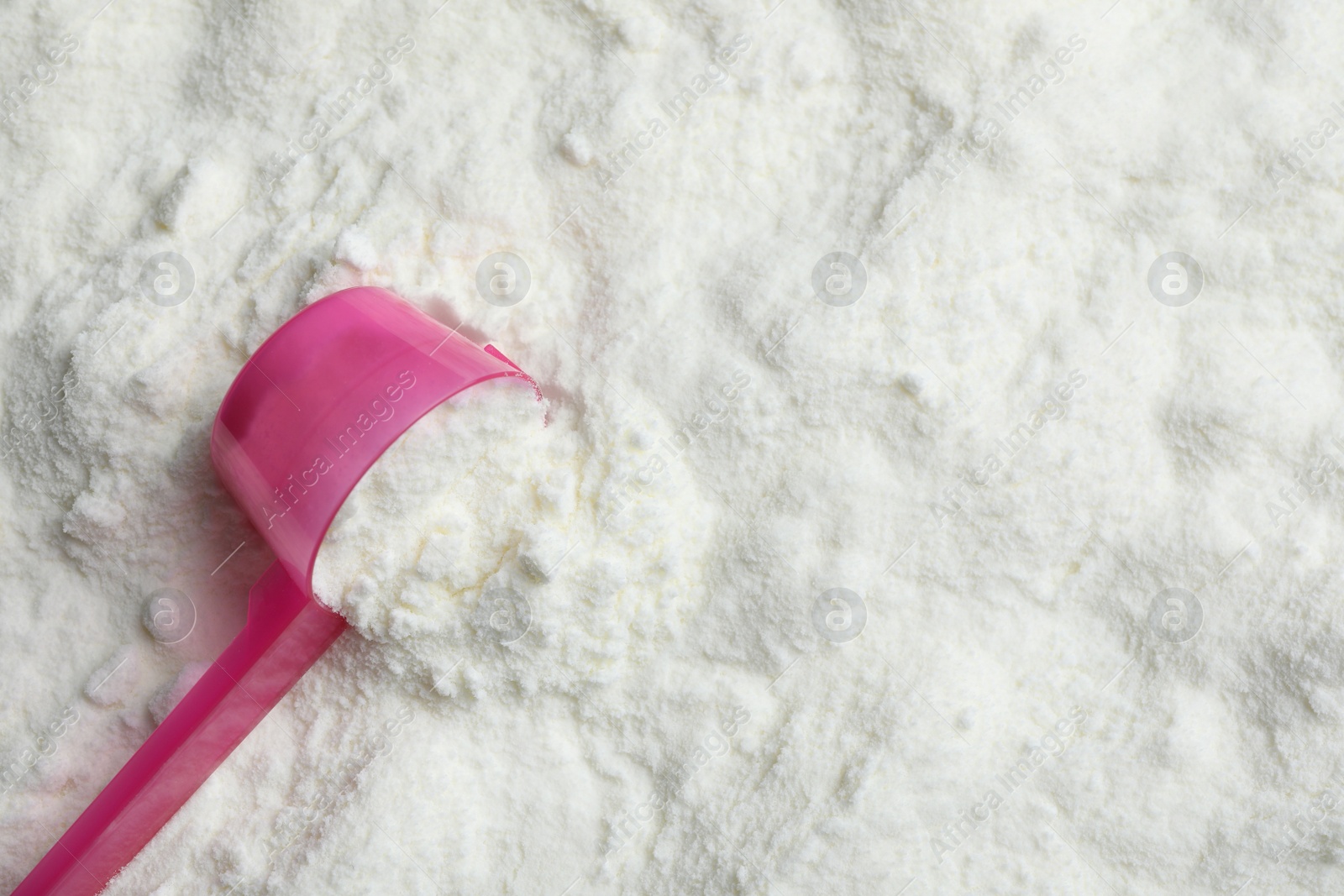 Photo of Top view of powdered infant formula and scoop, space for text. Baby milk