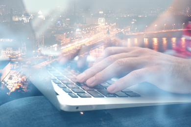 Image of Double exposure of male programmer using laptop and cityscape, closeup 