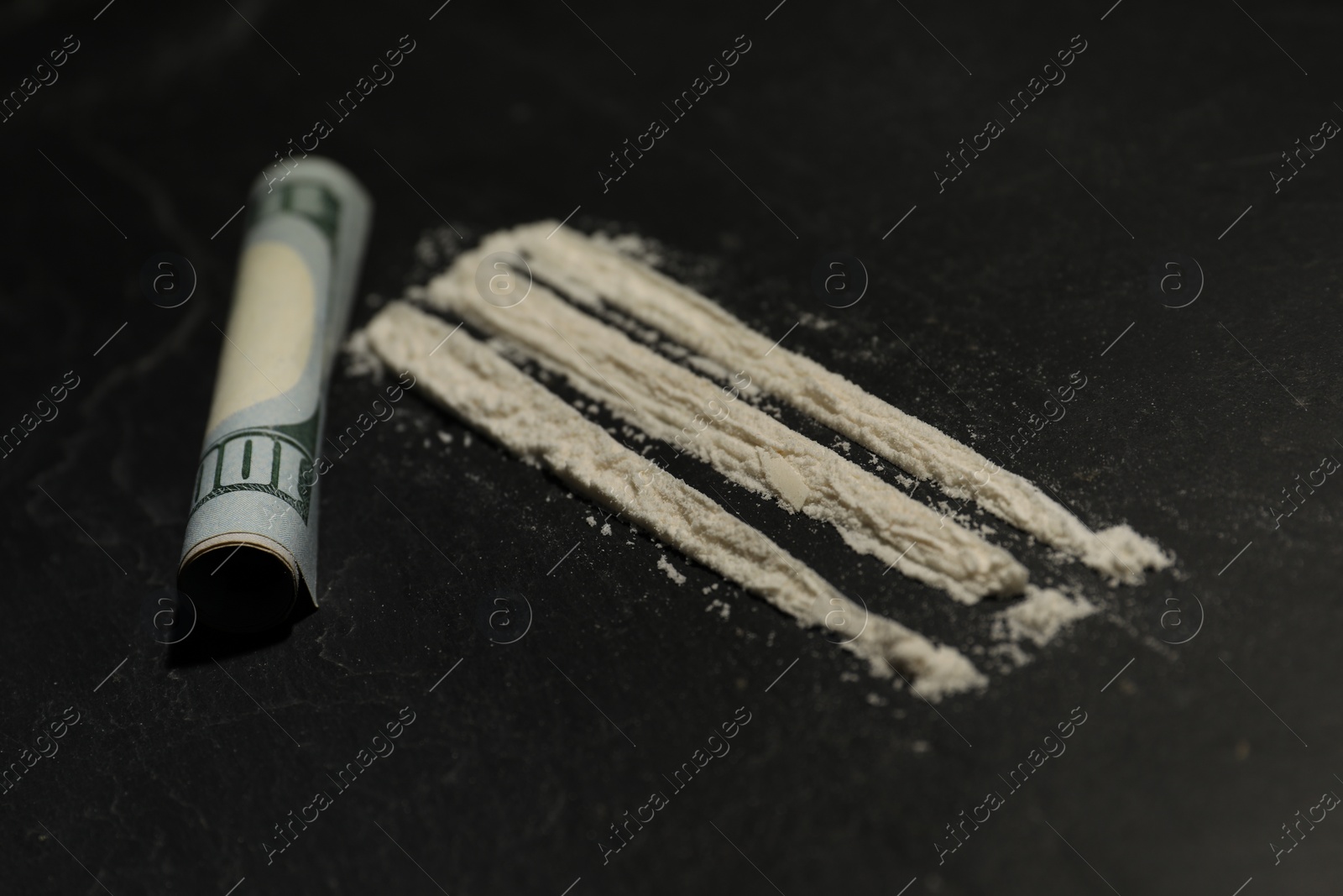 Photo of Drug addiction. Cocaine and rolled dollar banknote on grey textured table, closeup