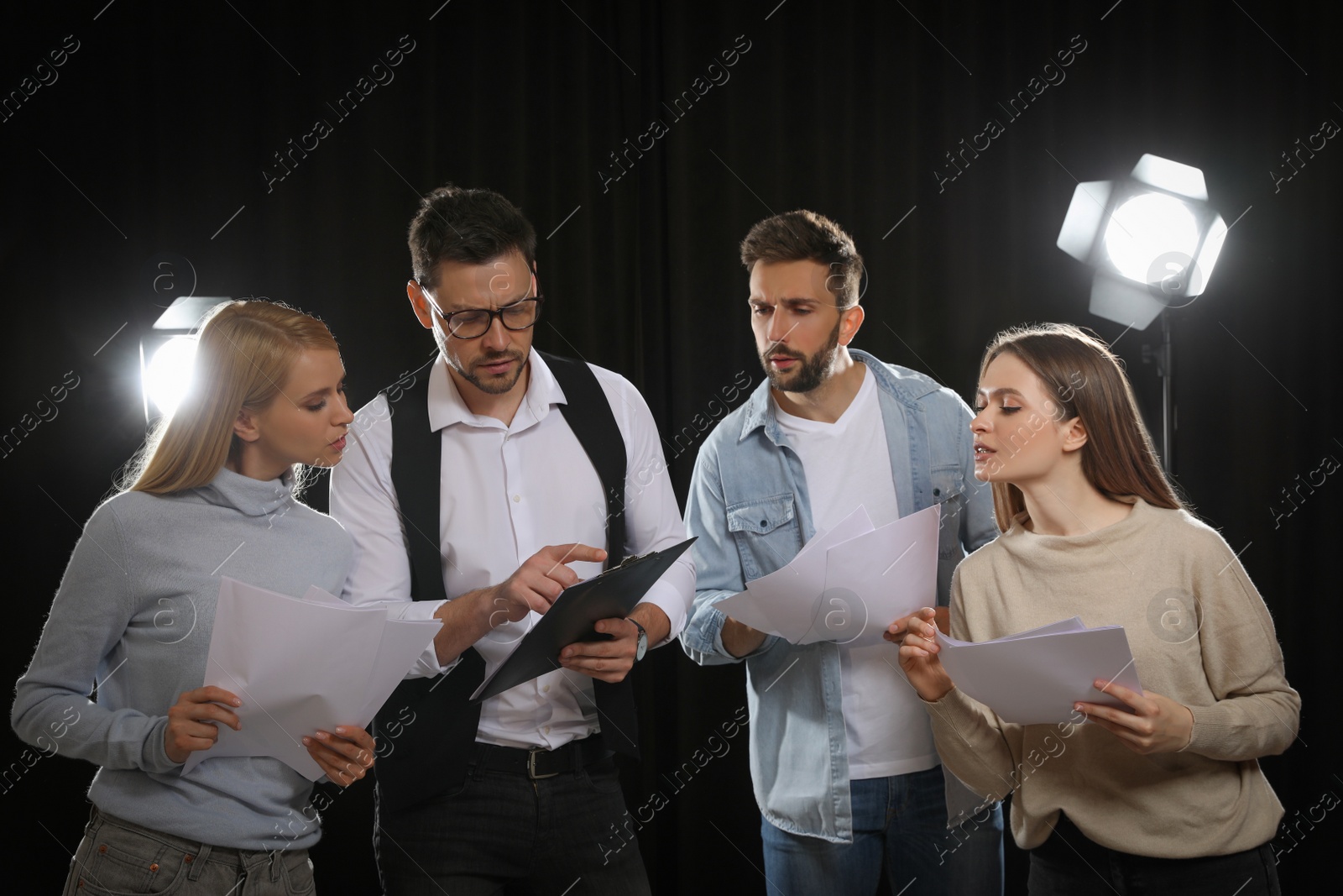 Photo of Professional actors reading their scripts during rehearsal in theatre