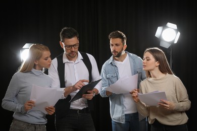 Photo of Professional actors reading their scripts during rehearsal in theatre
