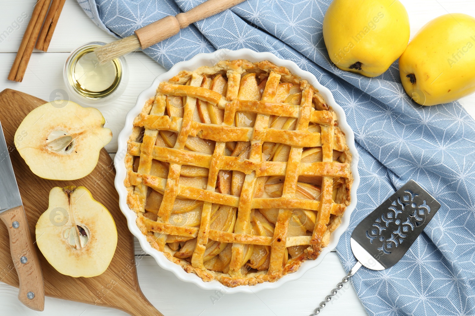 Photo of Tasty homemade quince pie, cake server and fresh fruits on white wooden table, flat lay