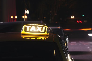Photo of Taxi car with yellow sign on city street at night