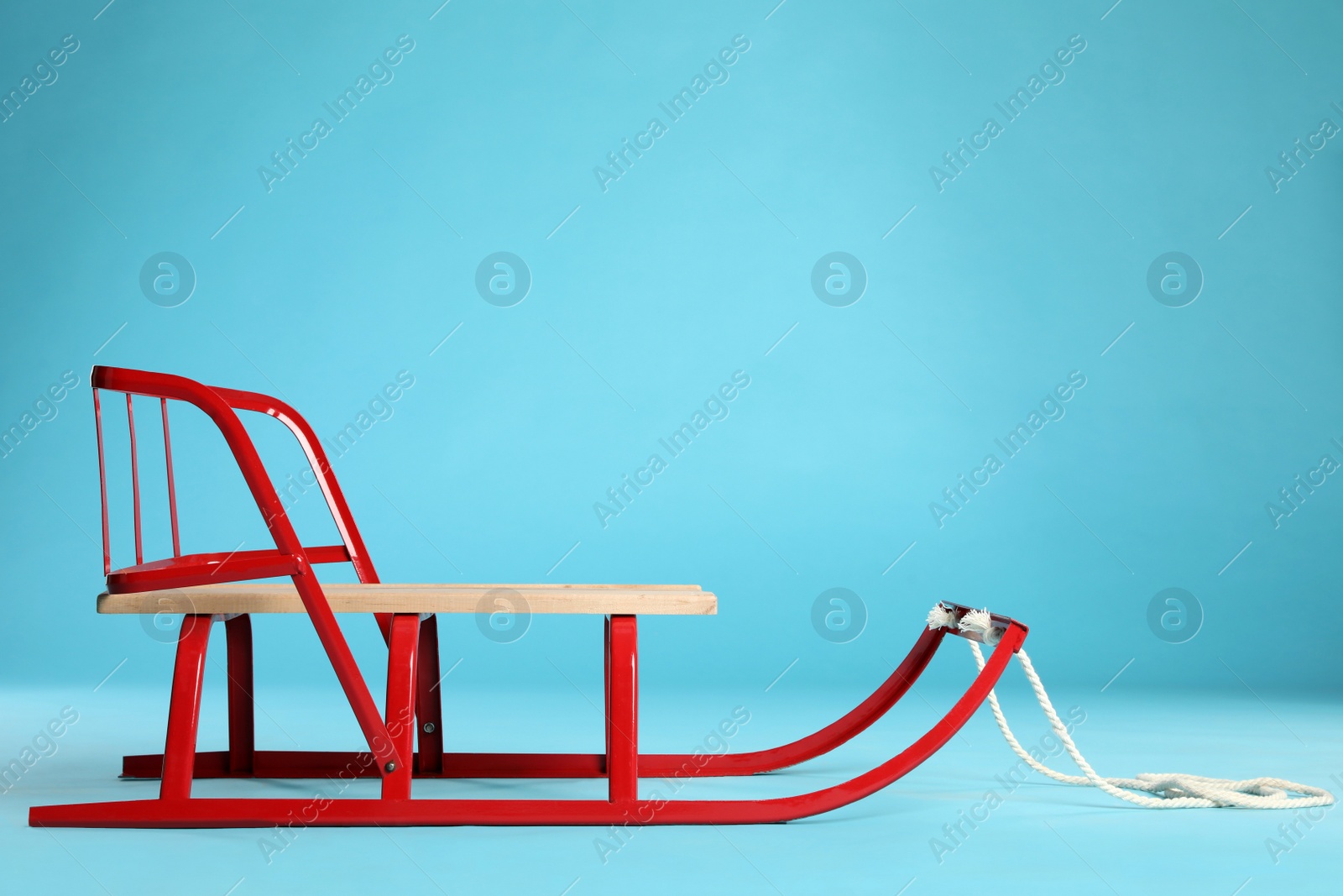 Photo of Sleigh on light blue background. Winter outdoor activity