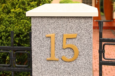 Photo of House number 15 on grey fence outdoors