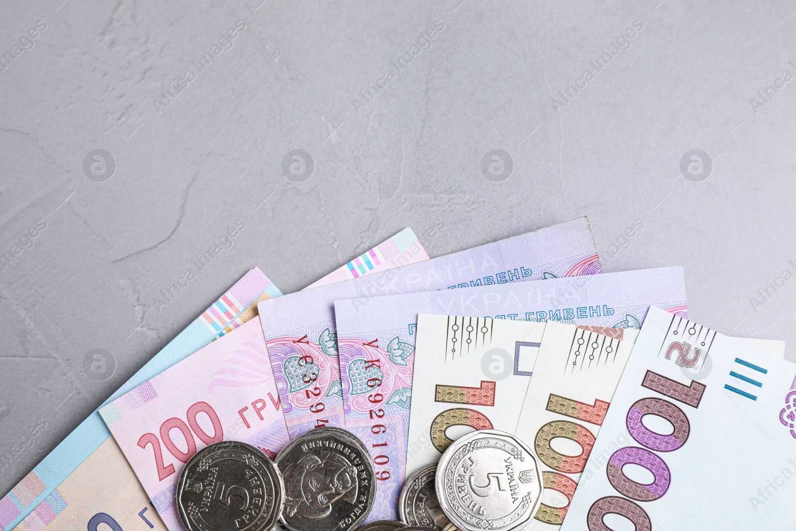 Photo of Ukrainian money on grey background, flat lay. Space for text