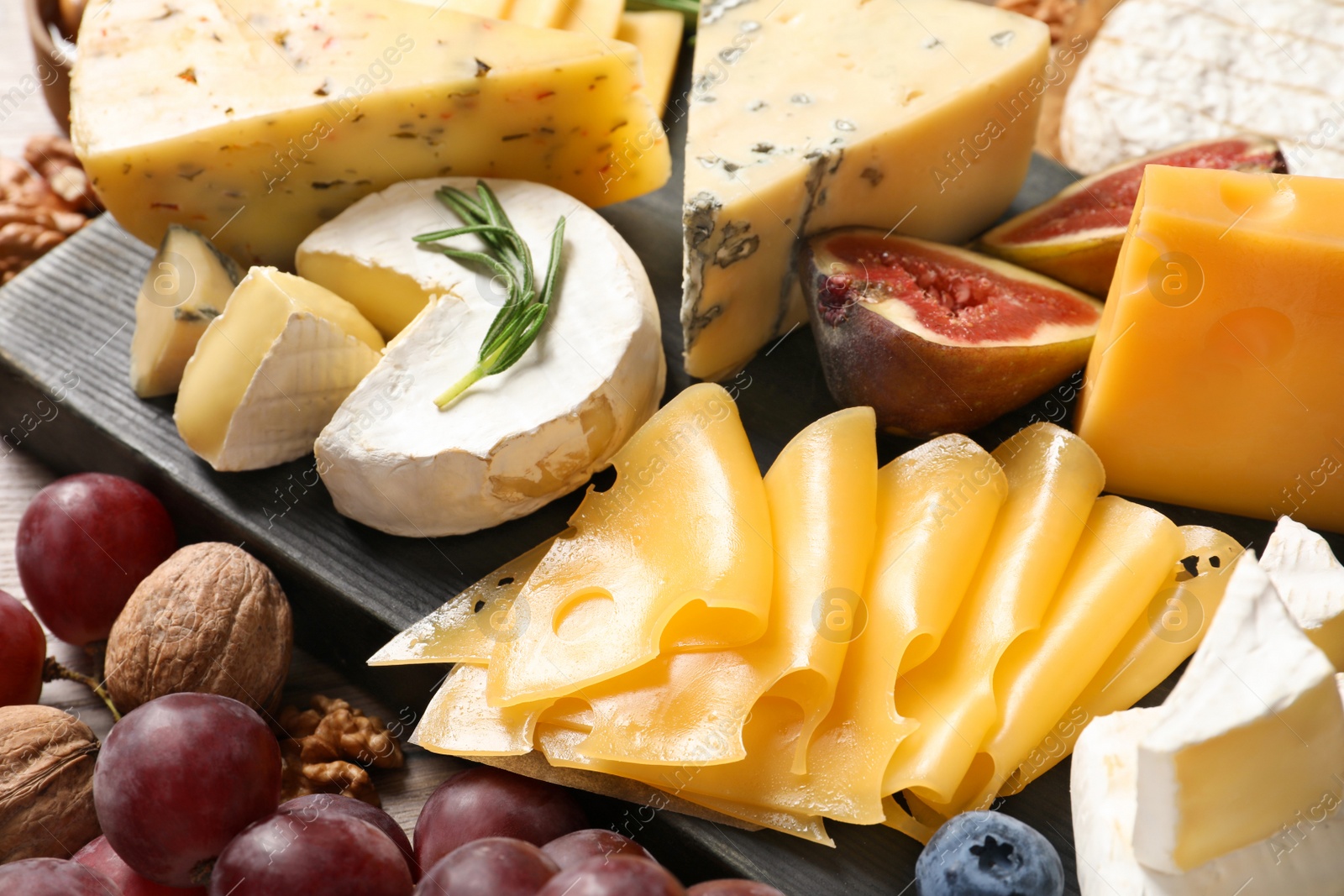 Photo of Composition with different delicious cheeses and fruits, closeup