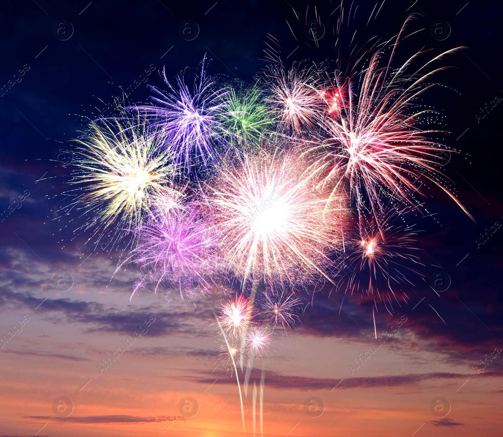 Image of Beautiful bright fireworks lighting up twilight sky outdoors