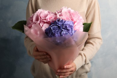 Photo of Woman with bouquet of beautiful hortensia flowers on color background, closeup