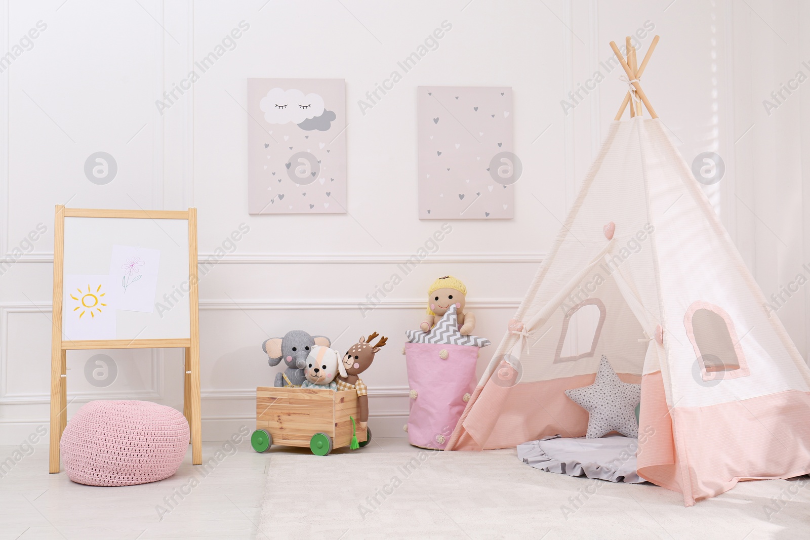 Photo of Cute child's room interior with toys, modern furniture and play tent