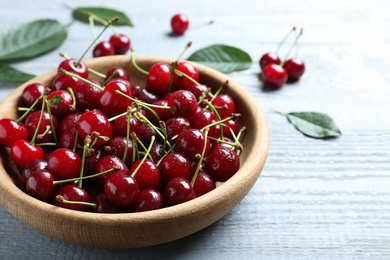 Sweet juicy cherries on blue wooden table, closeup