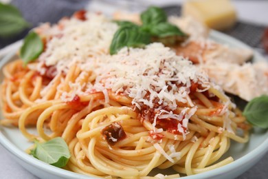Photo of Delicious pasta with tomato sauce, basil and parmesan cheese in plate, closeup
