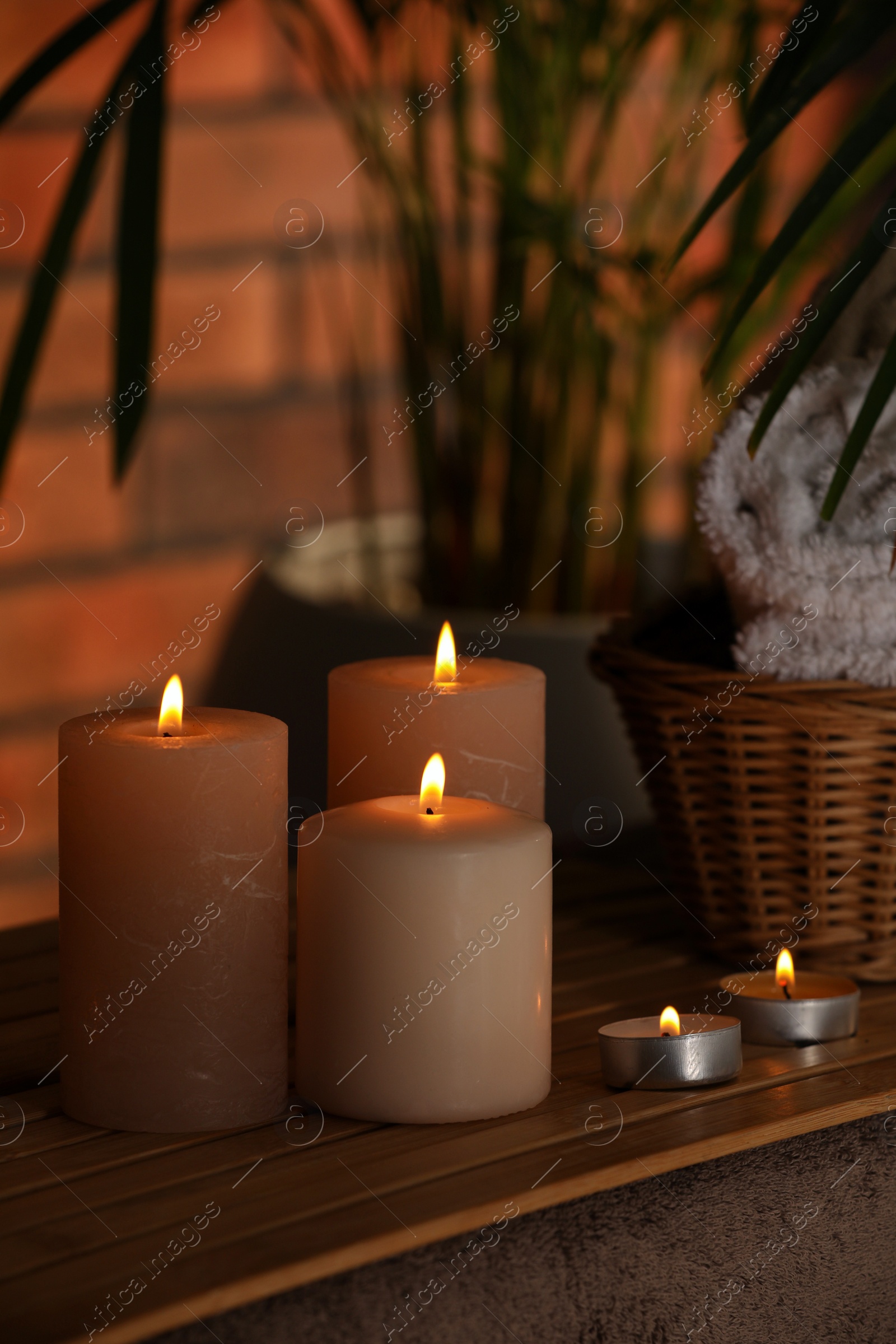 Photo of Spa composition with burning candles on massage table in wellness canter