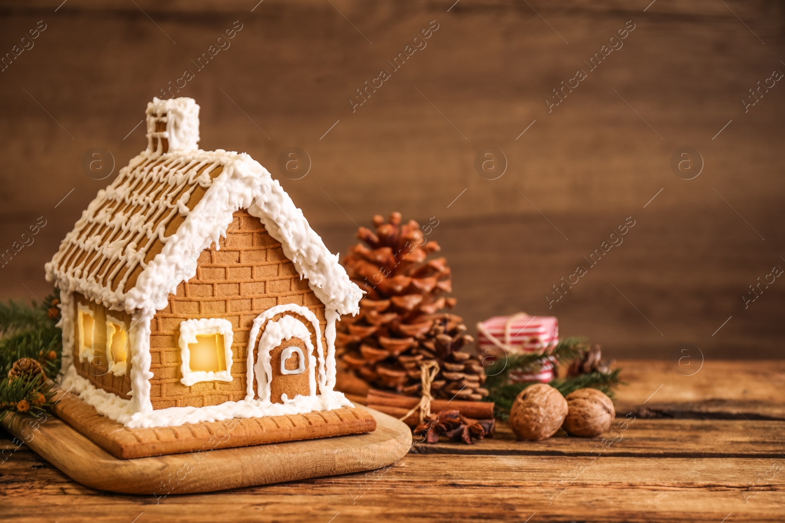 Photo of Beautiful gingerbread house decorated with icing on wooden table