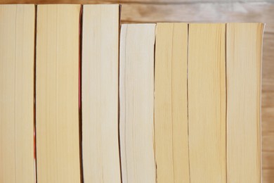 Collection of different books against wooden background, closeup