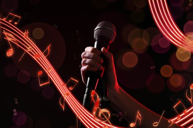 Woman holding microphone on black background, closeup. Music notes flowing around singer