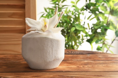 Photo of Fresh coconut drink in nut on wooden window sill