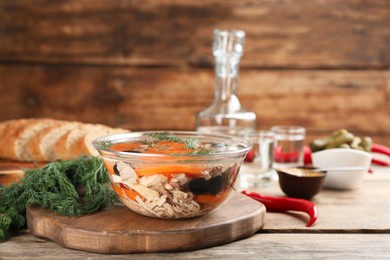 Photo of Delicious aspic with meat in bowl on wooden table