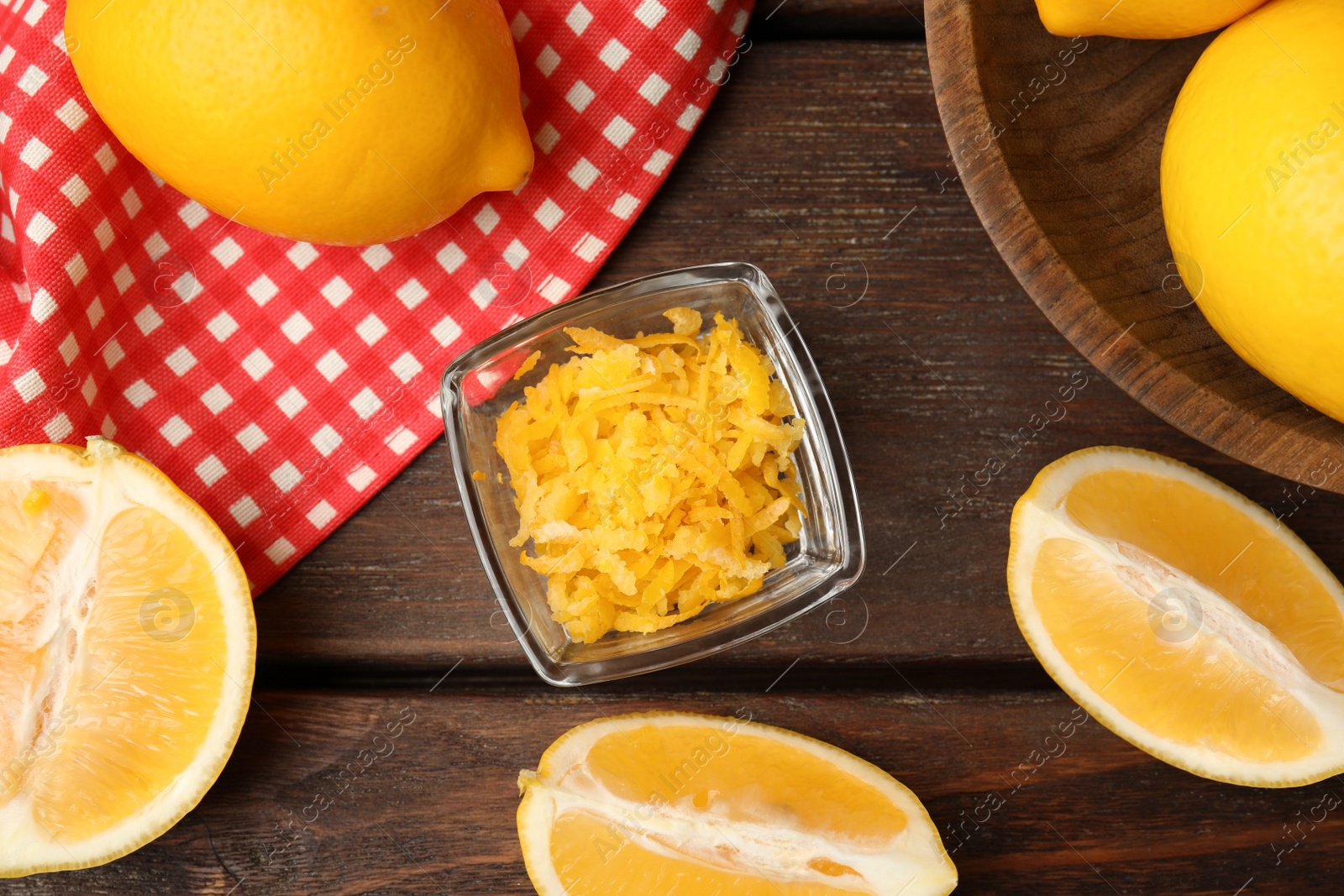 Photo of Grated lemon zest and fresh fruits on wooden table, flat lay