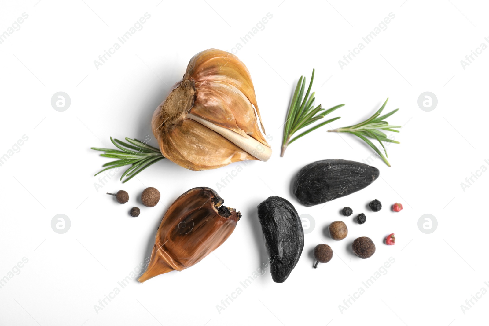 Photo of Aged black garlic with rosemary and peppercorns on white background, view from above