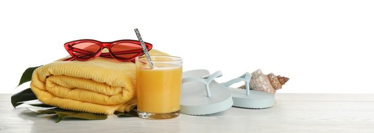 Different beach objects on wooden table against white background