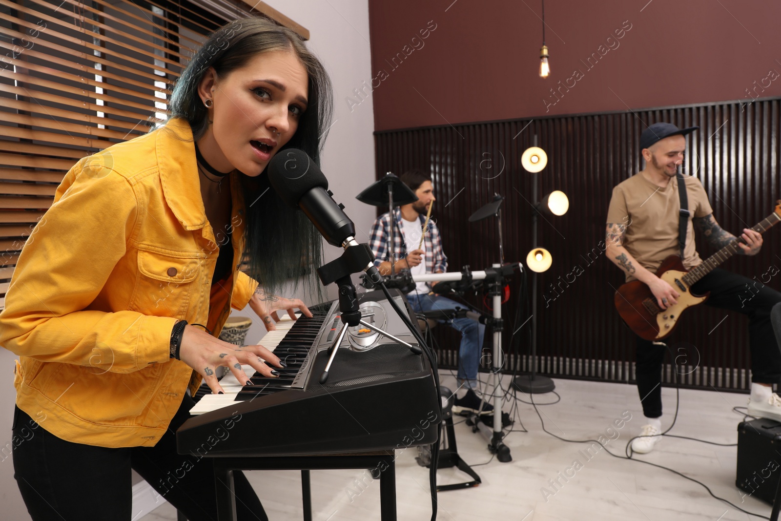 Photo of Music band performing in modern recording studio