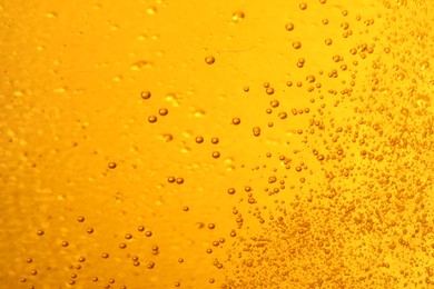 Photo of Tasty beer with bubbles as background, closeup