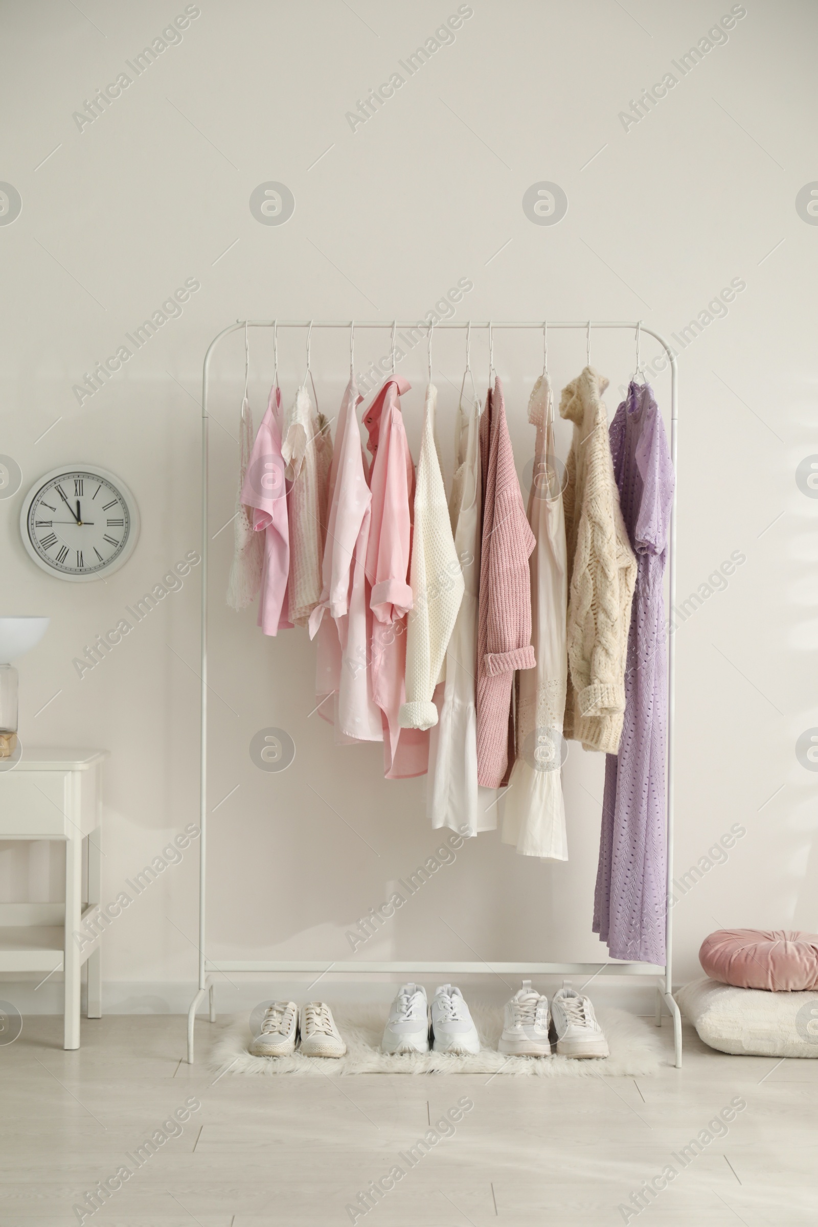 Photo of Rack with stylish women's clothes indoors. Interior design