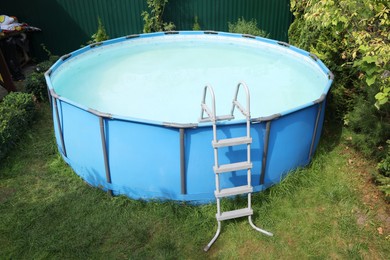 Photo of Above ground swimming pool on grass in backyard