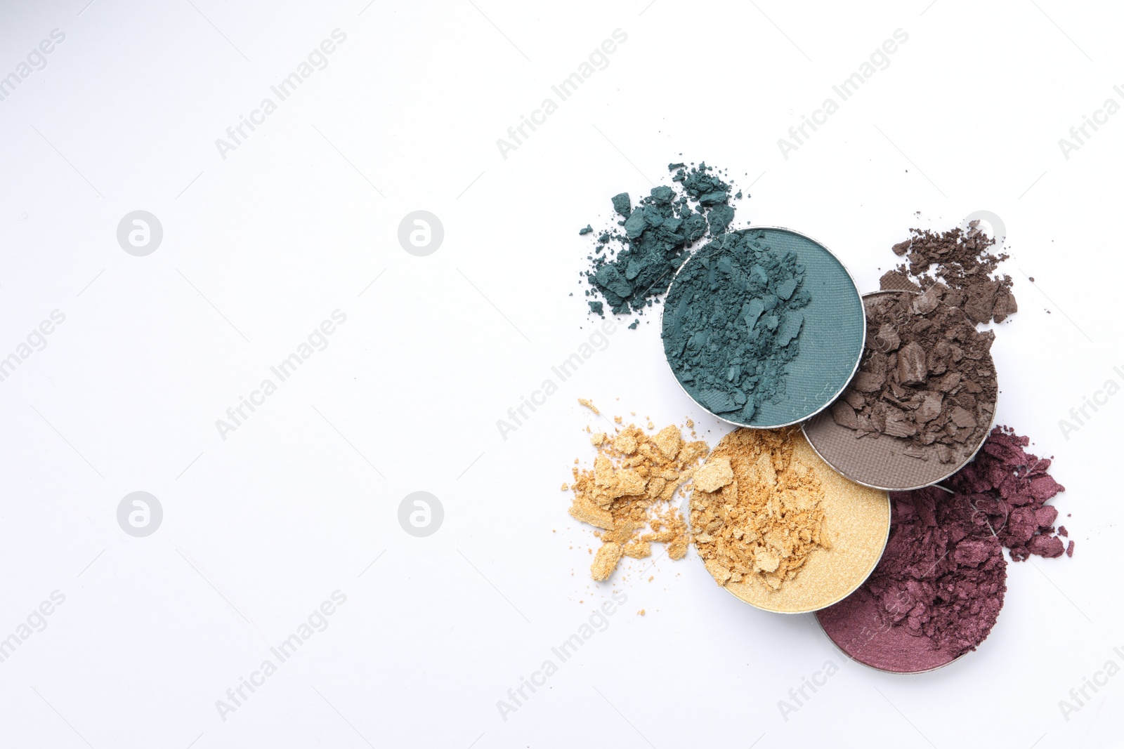 Photo of Different crushed eye shadows on white background, flat lay. Space for text