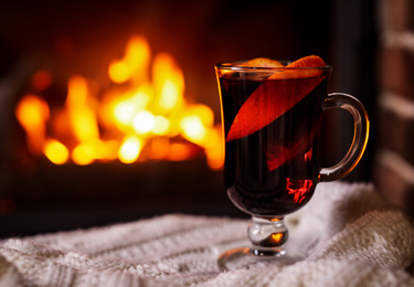 Delicious mulled wine and blurred fireplace on background