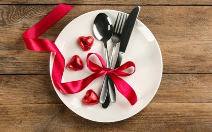 Photo of Beautiful table setting for Valentine's Day dinner on wooden background, top view