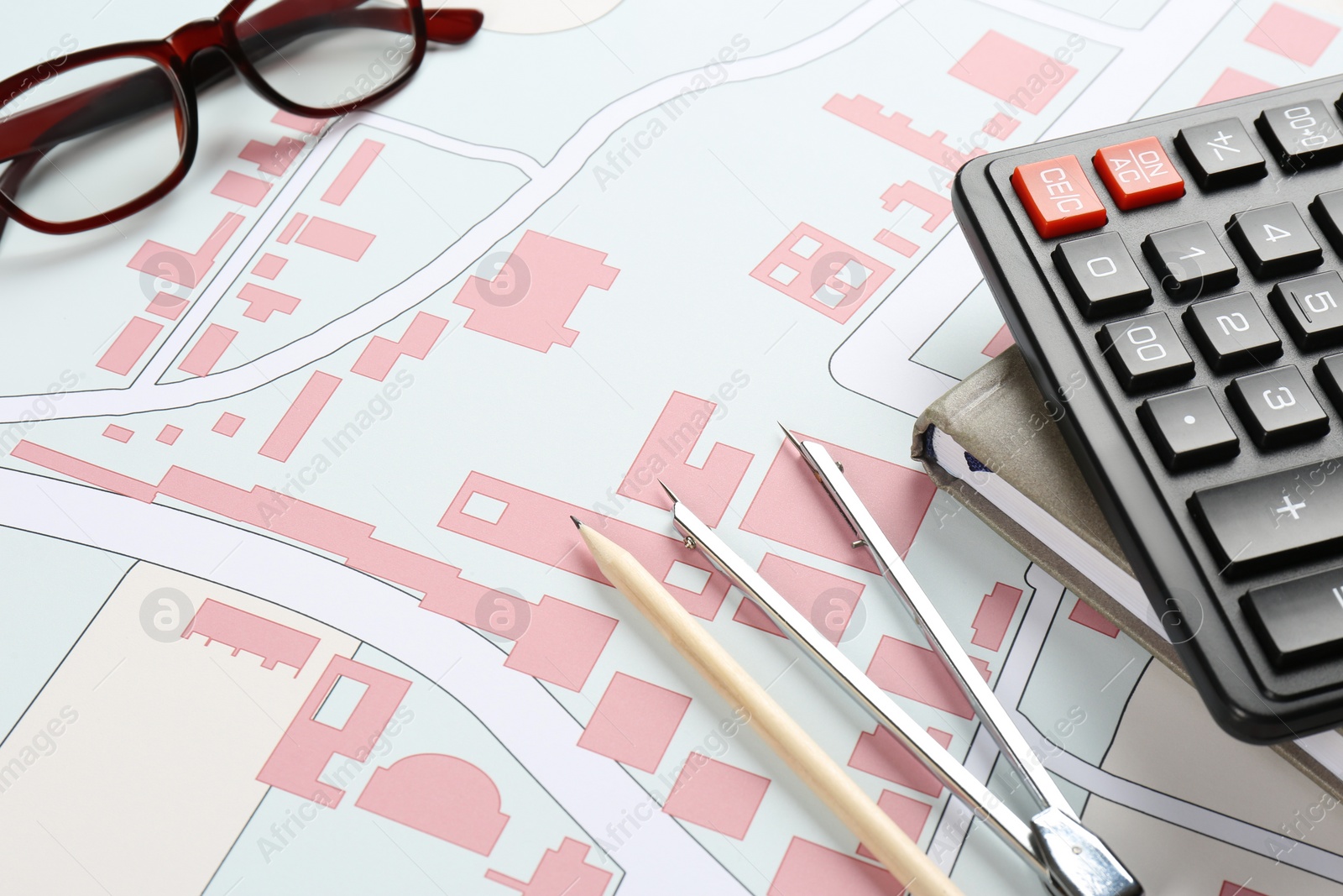 Photo of Office stationery and eyeglasses on cadastral map of territory with buildings