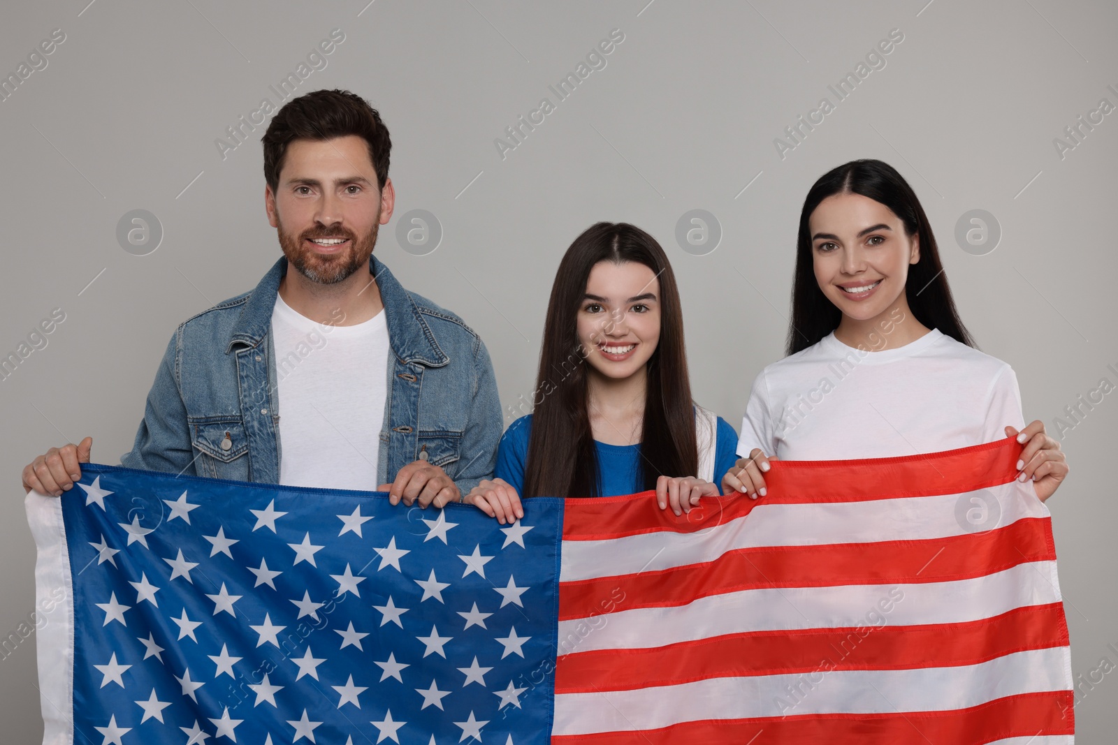 Photo of 4th of July - Independence Day of USA. Happy family with American flag on grey background