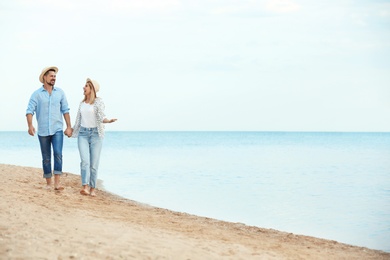 Photo of Happy romantic couple walking on beach, space for text