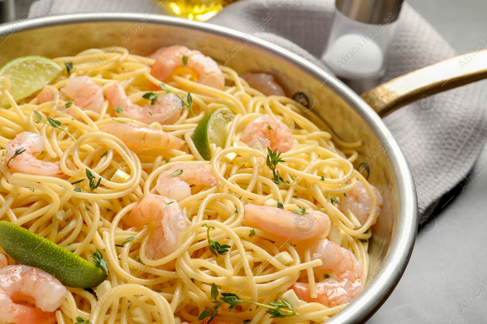 Photo of Frying pan with spaghetti and shrimps on table, closeup