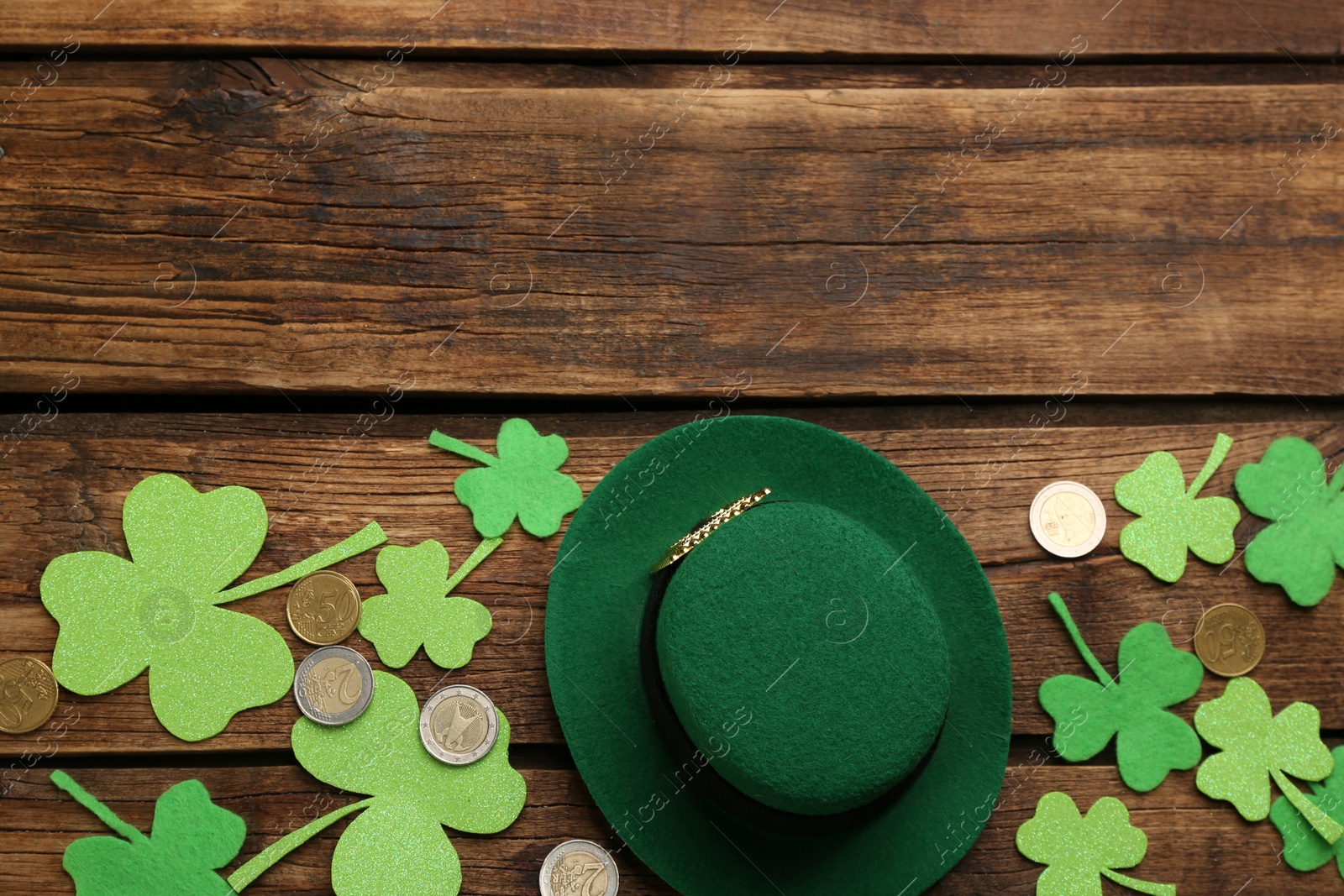 Photo of Flat lay composition with leprechaun hat on wooden table, space for text. St Patrick's Day celebration