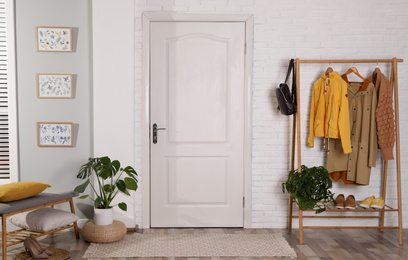 Photo of Hallway interior with stylish furniture, clothes and plants